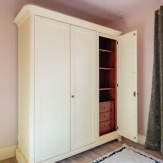 White painted wardrobe with cherry red drawers and storage compartments