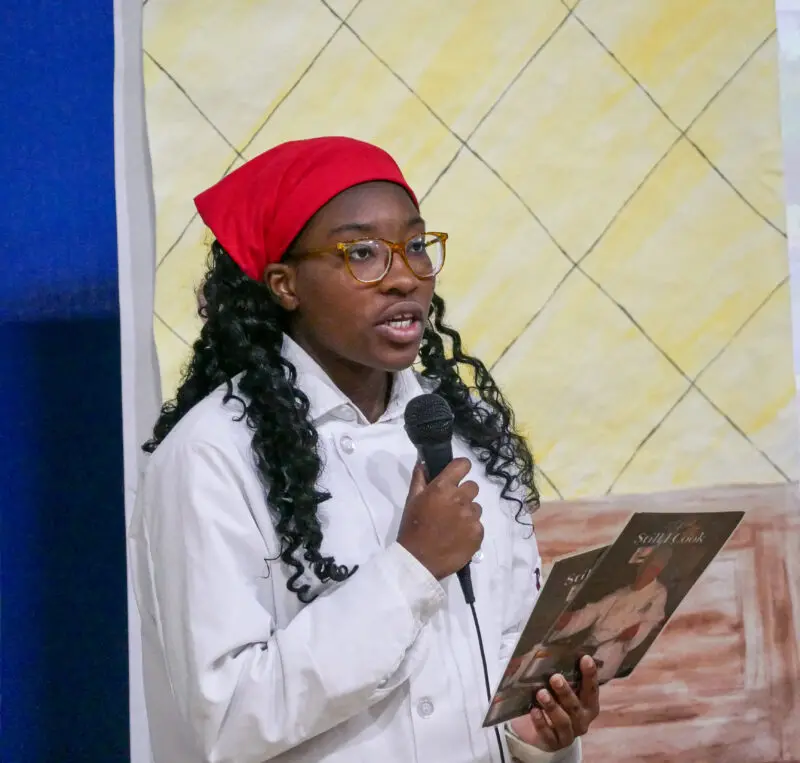 Saugus High School junior Aminat Arowolo portrays Leah Chase at the 14th Annual Women in History highlighting female chefs and how they changed the world through their food and recipes on Monday in the Saugus High School gym presented by the American Association of University Women. 040824 Katherine Quezada/The Signal