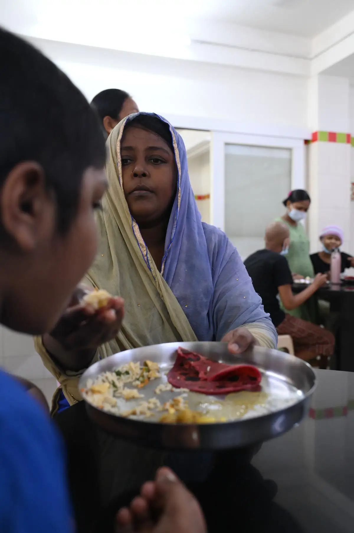 A mother feeding her child at St. Jude India ChildCare Centre, Chennai