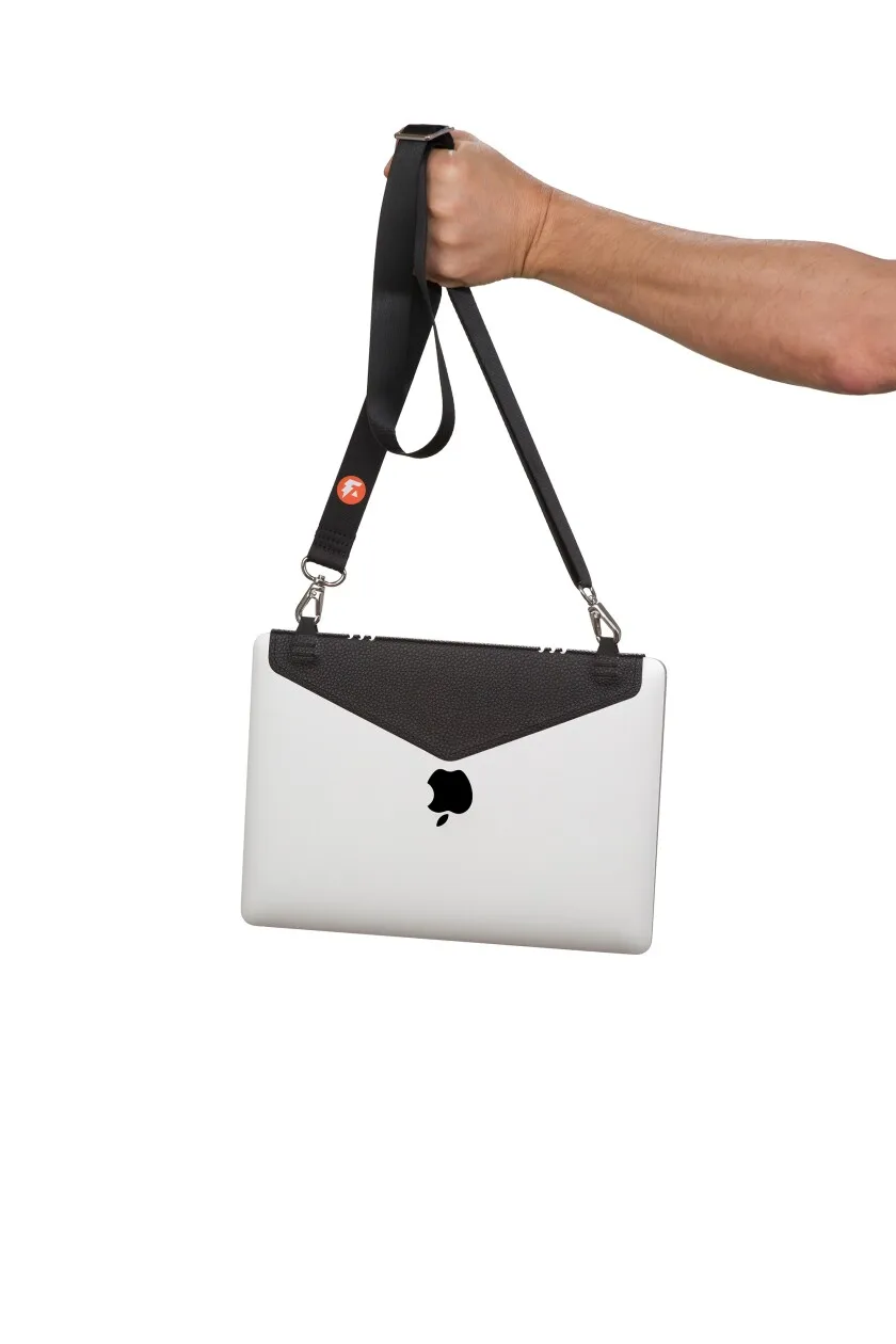 A person's arm holds a Macbook laptop by The Laptop Strap