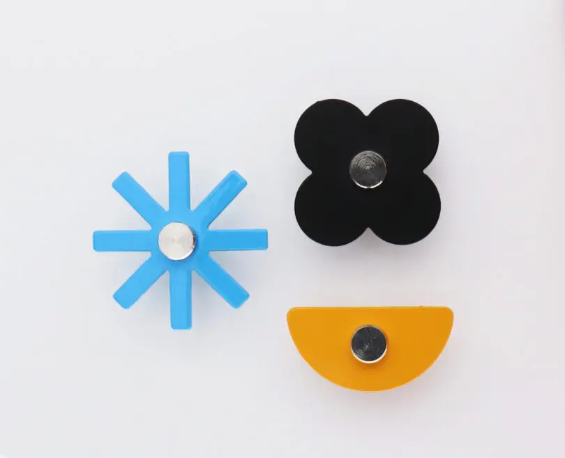 assorted magnets resembling flowers and different shapes on a white table