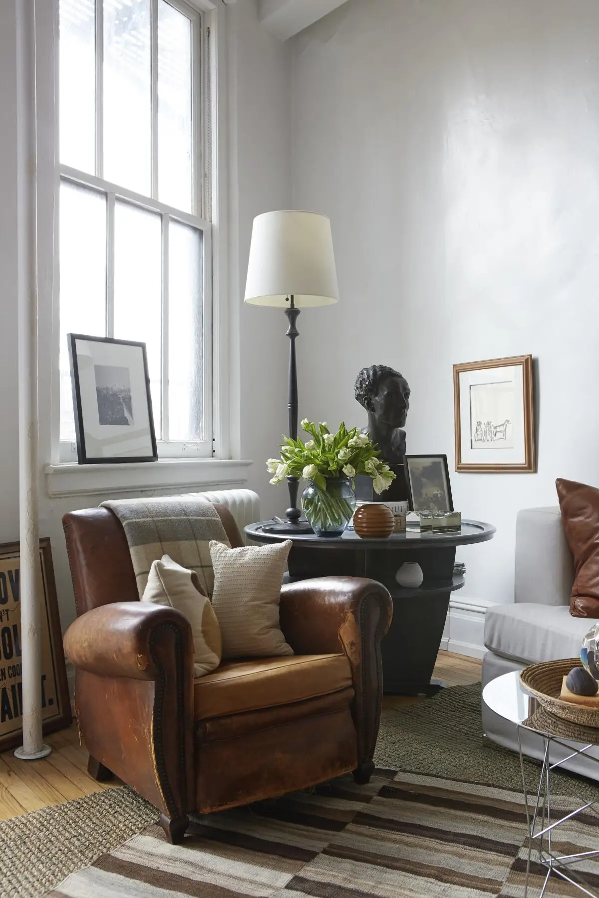 A vintage leather armchair and a two-tiered table.