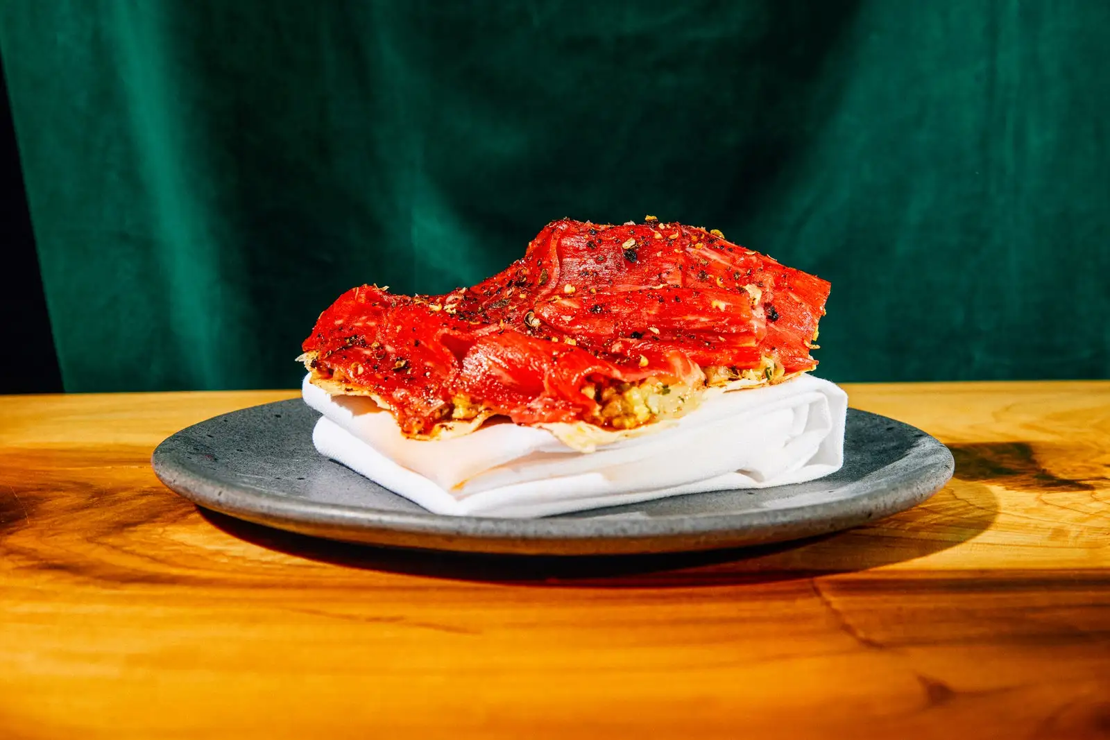 Shaved raw beef on a plate on a wooden table