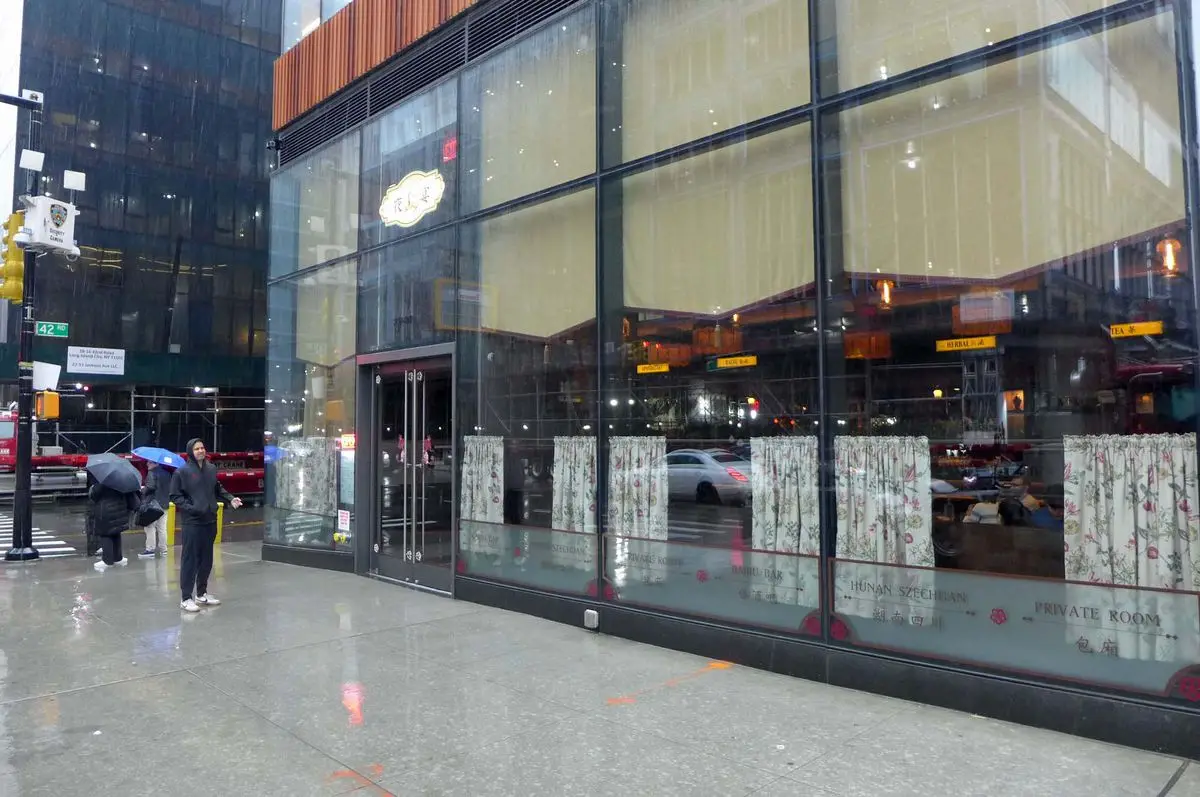 A rainy day, a long glass storefront with curtains.