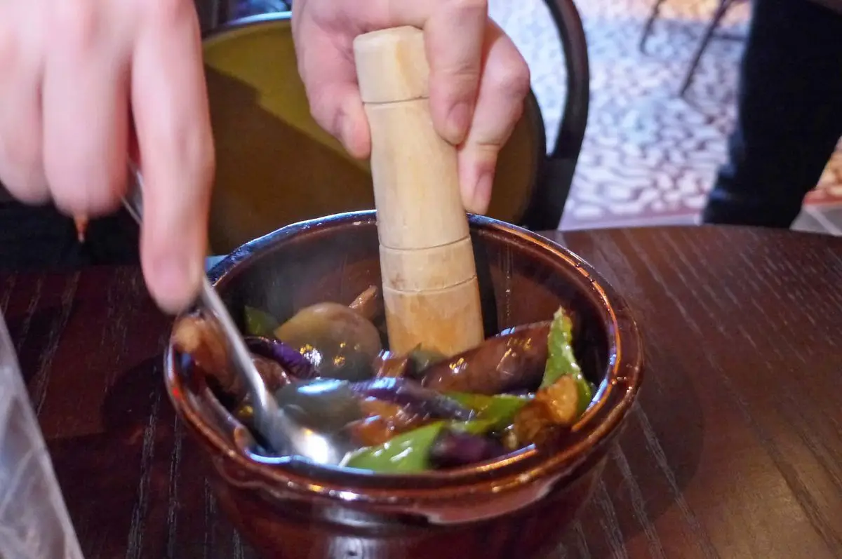 A pestle squishing ingredients.