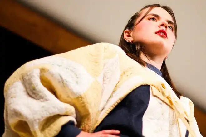 Modeling a denim mini dress with a quilted top designed by Claire Johnson, Eve Becherer looks on during Stephens College's 80th annual fashion show, “The Collections,” Saturday, April 13 at Windsor Auditorium Stephens College in Columbia.