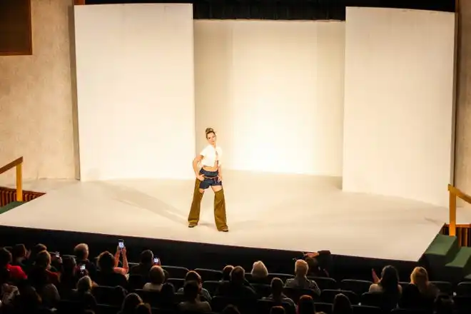 Modeling denim shorts with chaps designed by Katie Ciolino and Hannah Kleman, Ava Hercules poses in front of the audience during Stephens College's 80th annual fashion show, “The Collections,” Saturday, April 13 at Windsor Auditorium Stephens College in Columbia.