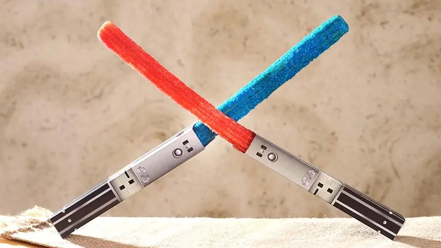 A photo of two crossed churros decorated to look like red and blue lightsabers.