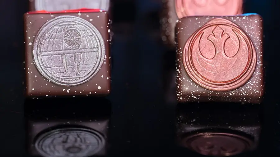 Two ganache squares, with the left featuring a Death Star medallion and the right featuring a Rebellion medallion.