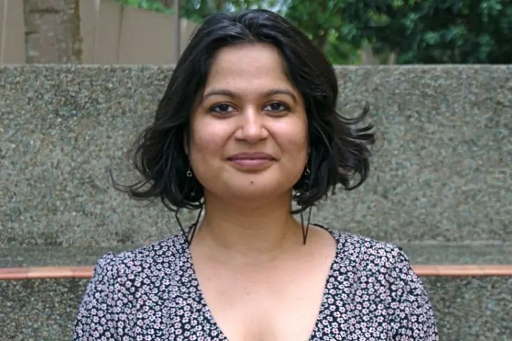 A woman with dark hair smiles.