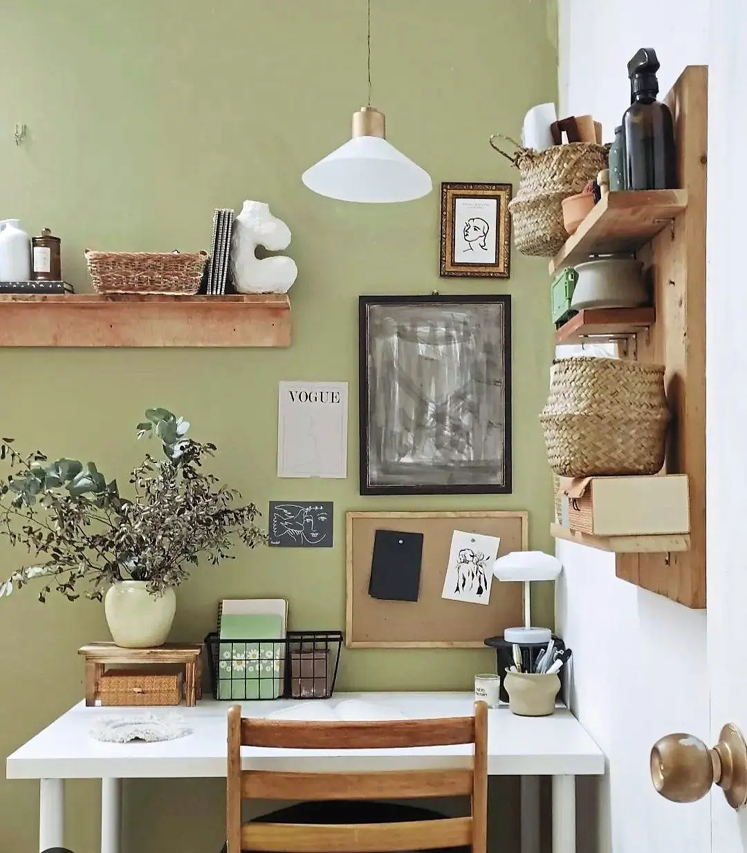 The study area features a creamy olive green colour along with lots of white and wood accents to give it a bright and airy setting.