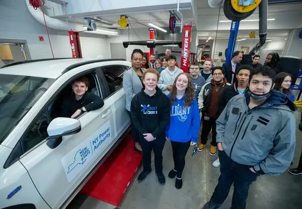 Group of automotive students examine their new electric vehicle