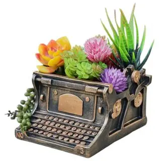 Resin typewriter-shaped planter with florals in it