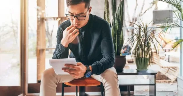 Person with glasses studying notes