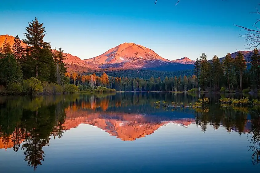 A view of Lassen Peak overlooking a quiet lake. 