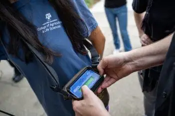 A man (Ty Werdel, Ph.D., assistant professor in the Texas A&M University Department of Rangeland, Wildlife and Fisheries Management) helps students with radio frequency gear