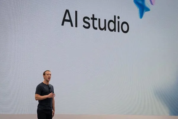 A man wearing a T-shirt stands in front a sign saying AI studio