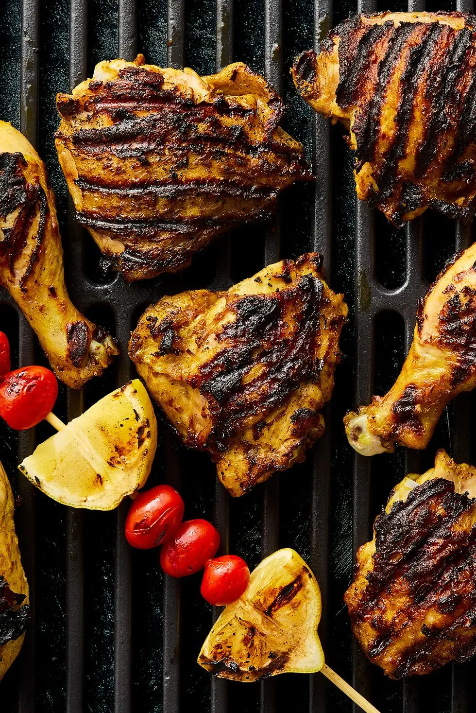 grilled chicken with grilled lemon wedges, tomatoes topped with parsley and mint