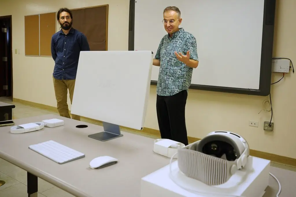 Kūlia Academy artificial intelligence/data science teacher Lutfi Sun, from left, and interim executive director Andy Gokce set up one of the charter school’s Apple Vision Pro headsets Wednesday, April 24, 2024, in Honolulu. This tuition-free charter school specializing in AI and data since only accepts 100 sixth graders. (Kevin Fujii/Civil Beat/2024)