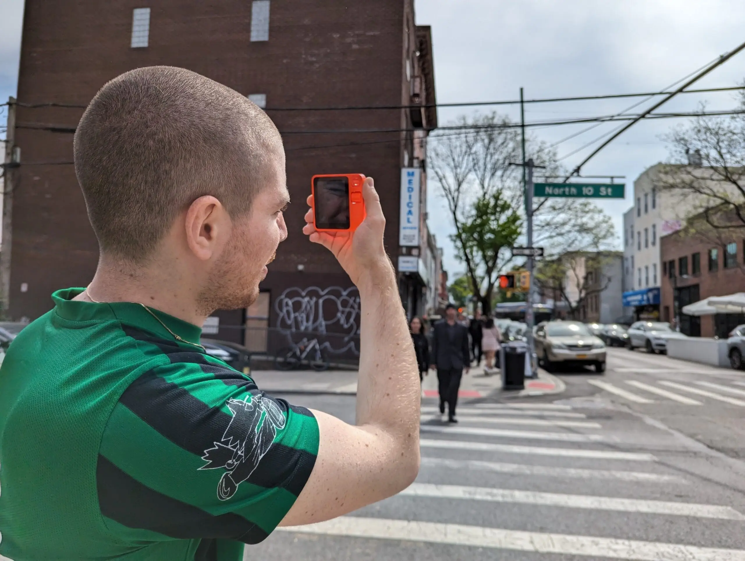 PHOTO: Artist Danny Cole tests out his Rabbit R1 on a street corner, April 30, 2024, in Brooklyn, N.Y.