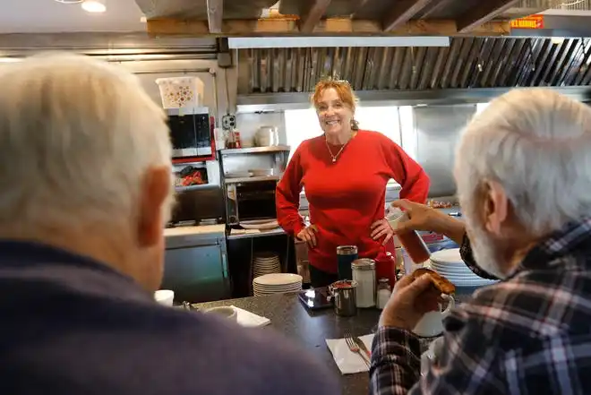 Sarah Simmons, owner, is all smiles to the regulars at the counter of the Little Phoenix Restaurant on Acushnet Avenue in New Bedford.