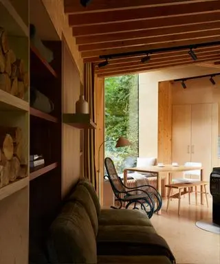 A lake house with high raftered ceilings, a green velvet sofa and natural light