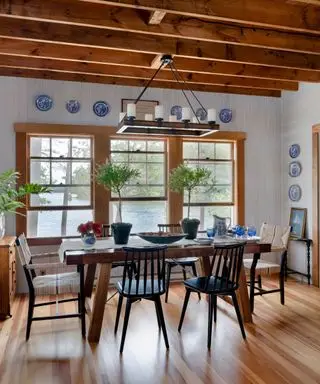 A lake house-style living room with a large dining table and an outdoor view