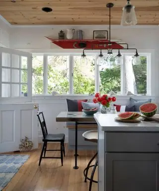 A lake house dining nook with watermelon on the counter and an outdoor view