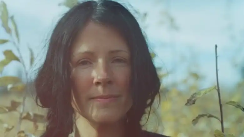 A woman with black hair smiles into the camera.