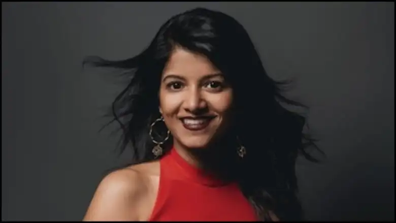 A woman with black hair looks at the camera.