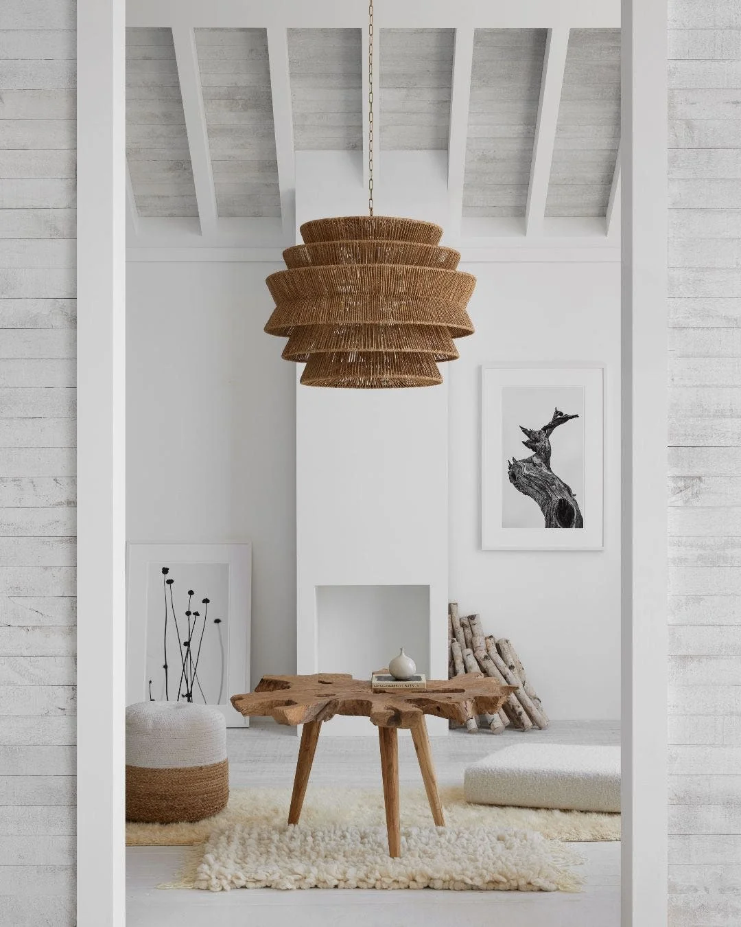 A room with a tan statement lamp and unique wood table