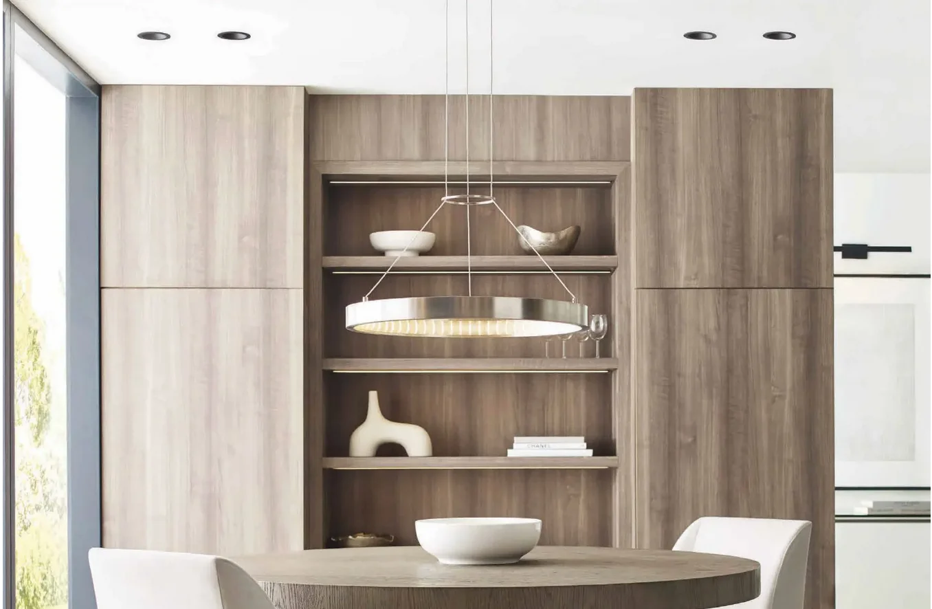 A dining room with a rounded light fixture and built-in shelves