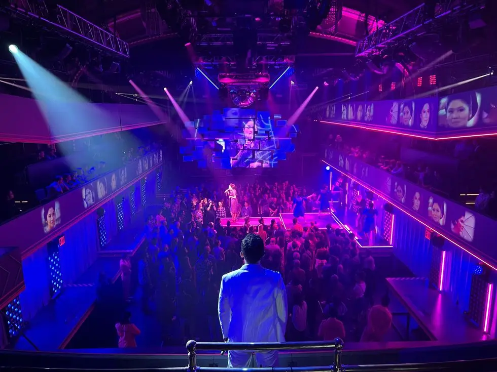 a man standing on a stage with a crowd watching