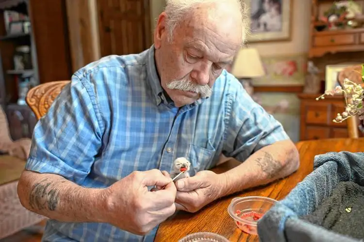 Tom Ricardi of the Birds of Prey Rehabilitation Center in Conway feeds a days-old baby screech owl.