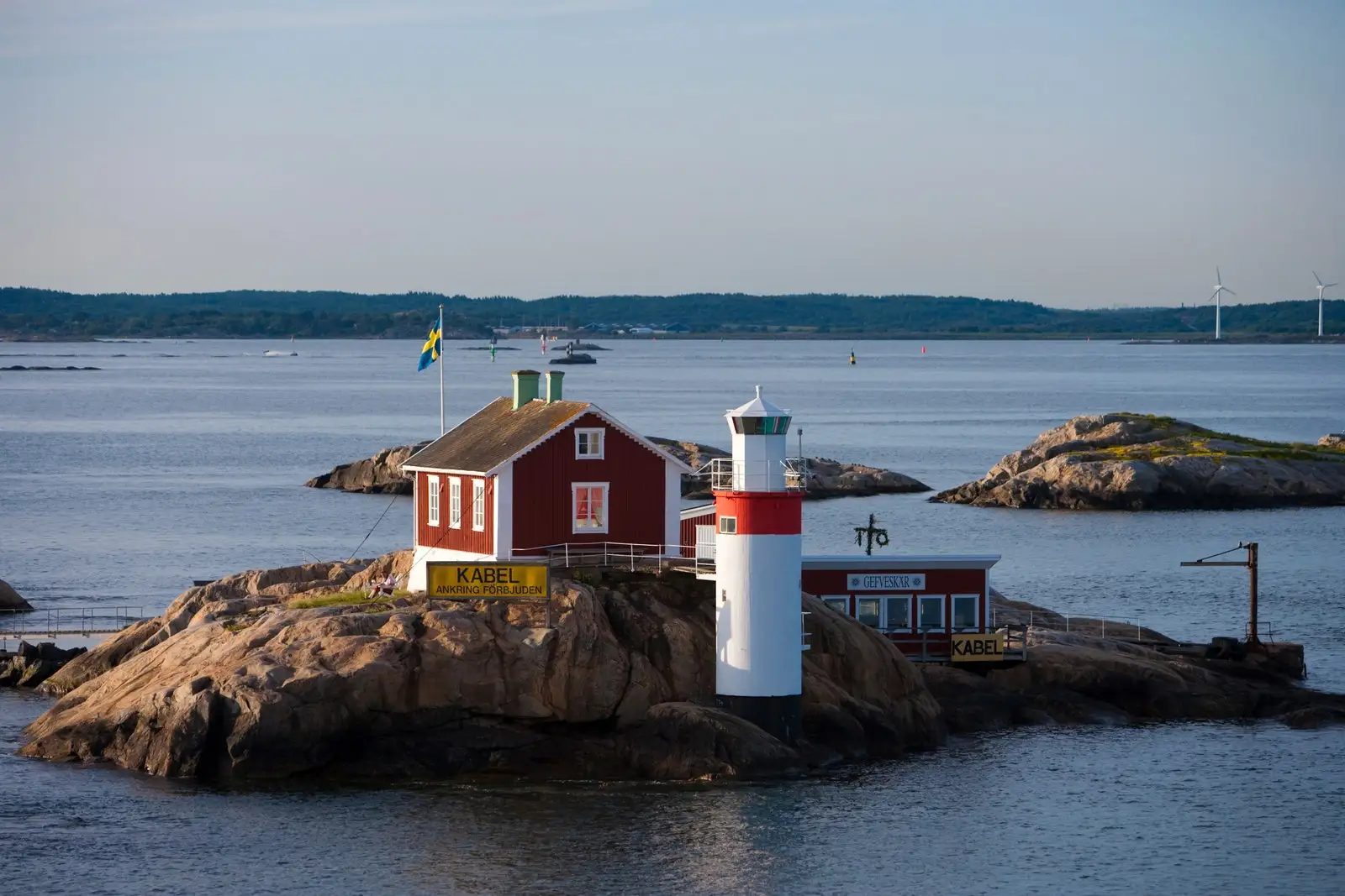 Lighthouse and red house on rocky island in Gothenburg archipelago near Goteborg.