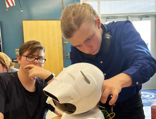 Sean-Patrick Schmitz, right, a senior at Erie High School, troubleshoots a bubble blowing assistive robot with Silver Creek High junior Spencer Freeman on April 22 at the St. Vrain Valley Innovation Center in Longmont. (Amy Bounds/Staff Writer)