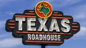 An outside and closeup view of a Texas Roadhouse, Inc. (TXRH) sign