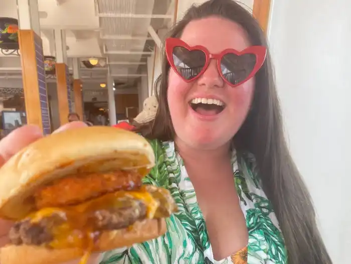 guy's burger joint Megan duBois holding up burger smiling