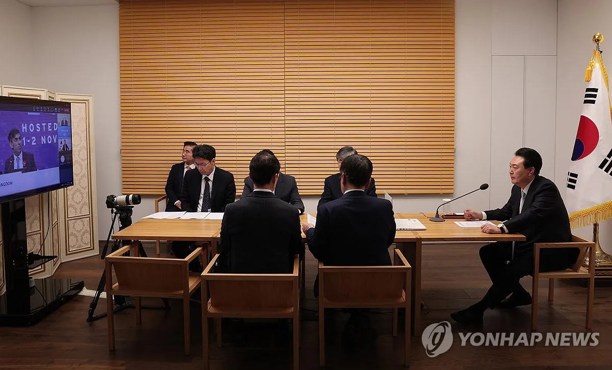 In this file photo, President Yoon Suk Yeol (R) attends the global AI Safety Summit at the presidential office in Seoul on Nov. 2, 2023, via a videoconference system. Yoon took part in the inaugural event held at Bletchley Park in central England to discuss global cooperation measures for the safe use and governance of artificial intelligence, his office said in a press release. (Yonhap)