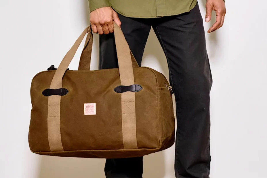 A person holding a Filson bag