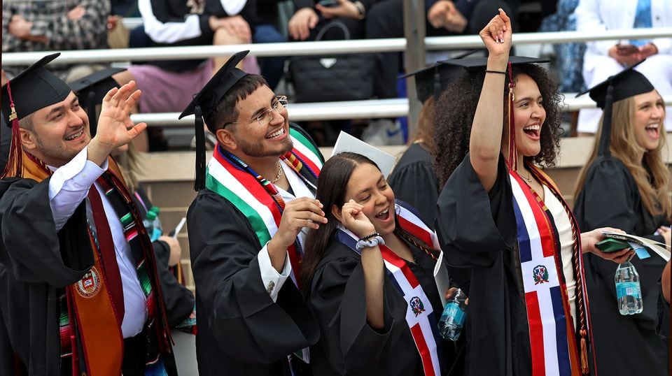 Boston College students graduate in traditional fashion, with mentions of global tensions