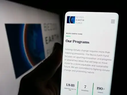 Person holding cellphone with webpage of environmental organization Bezos Earth Fund