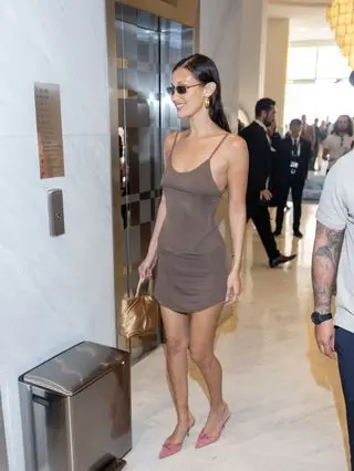 Bella Hadid wears a brown dress with pink heels.