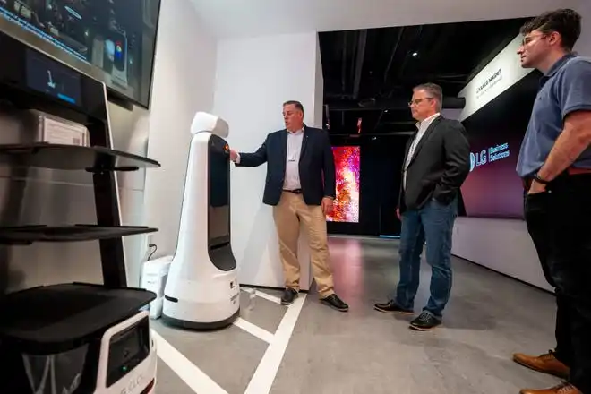 May 21, 2024; Englewood Cliffs, New Jersey, USA; David Bacher, head of marketing at LG Business Solutions USA, discusses one of the autonomous GuideBots with Paul Vitellaro and Tom Terzulli at LG's new innovation center on Tuesday.