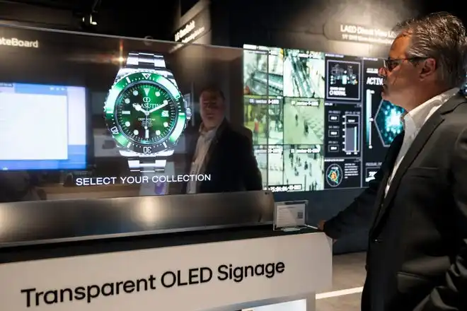 May 21, 2024; Englewood Cliffs, New Jersey, USA; David Bacher, head of marketing at LG Business Solutions USA, can be seen behind a transparent OLED sign as Paul Vitellaro looks on at LG's new innovation center on Tuesday.