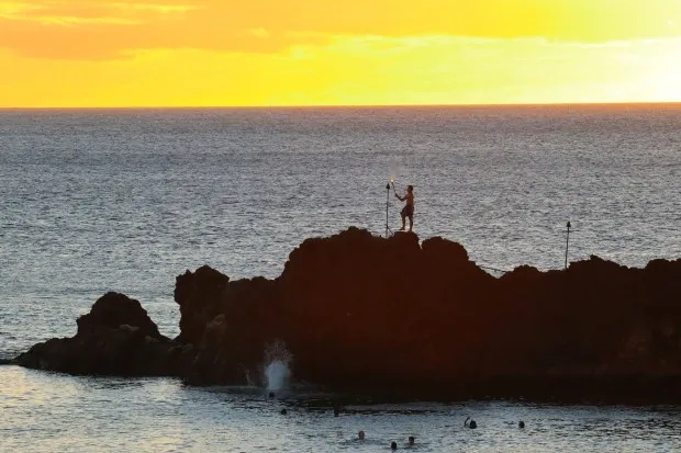 A sunset torch-lighting ceremony takes place nightly at Pu'u Keka'a (aka Black Rock), Ka'anapali Beach. (Photo by Ben Davidson Photography)