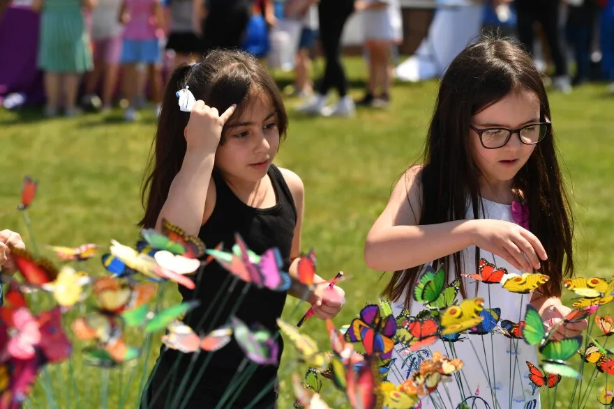 Riverside first-grade students Julianna Stull and Samira Khandi pick butterflies from the Northeast Suicide Prevention Initiative table.