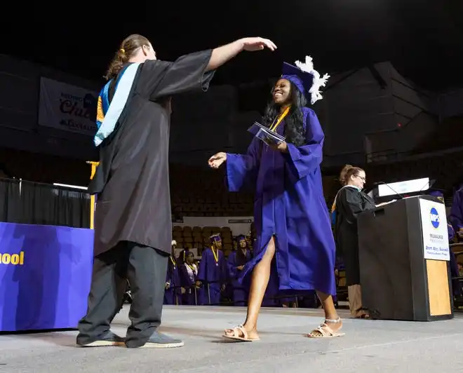 Washington High School of Information Technology student Quintonique McGee hugs Principal Alex Kuxhause after receiving her diploma during the graduation ceremony on Thursday May 23, 2024 at the UWM Panther Arena in Milwaukee, Wis.