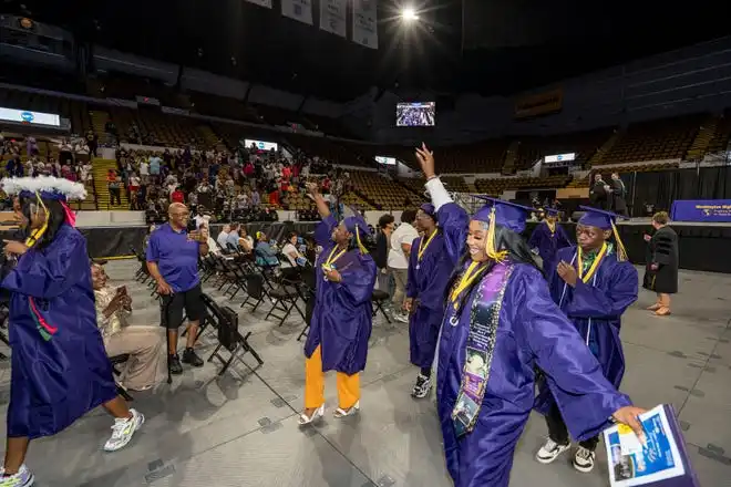 Washington High School of Information Technology graduates wave to their families at the end of the graduation ceremony on Thursday May 23, 2024 at the UWM Panther Arena in Milwaukee, Wis.