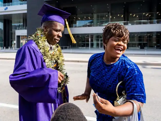 Washington High School of Information Technology graduate Bienvenu Bululu is congratulated by sibling Riziki Bululu after the graduation ceremony on Thursday May 23, 2024 at the UWM Panther Arena in Milwaukee, Wis.